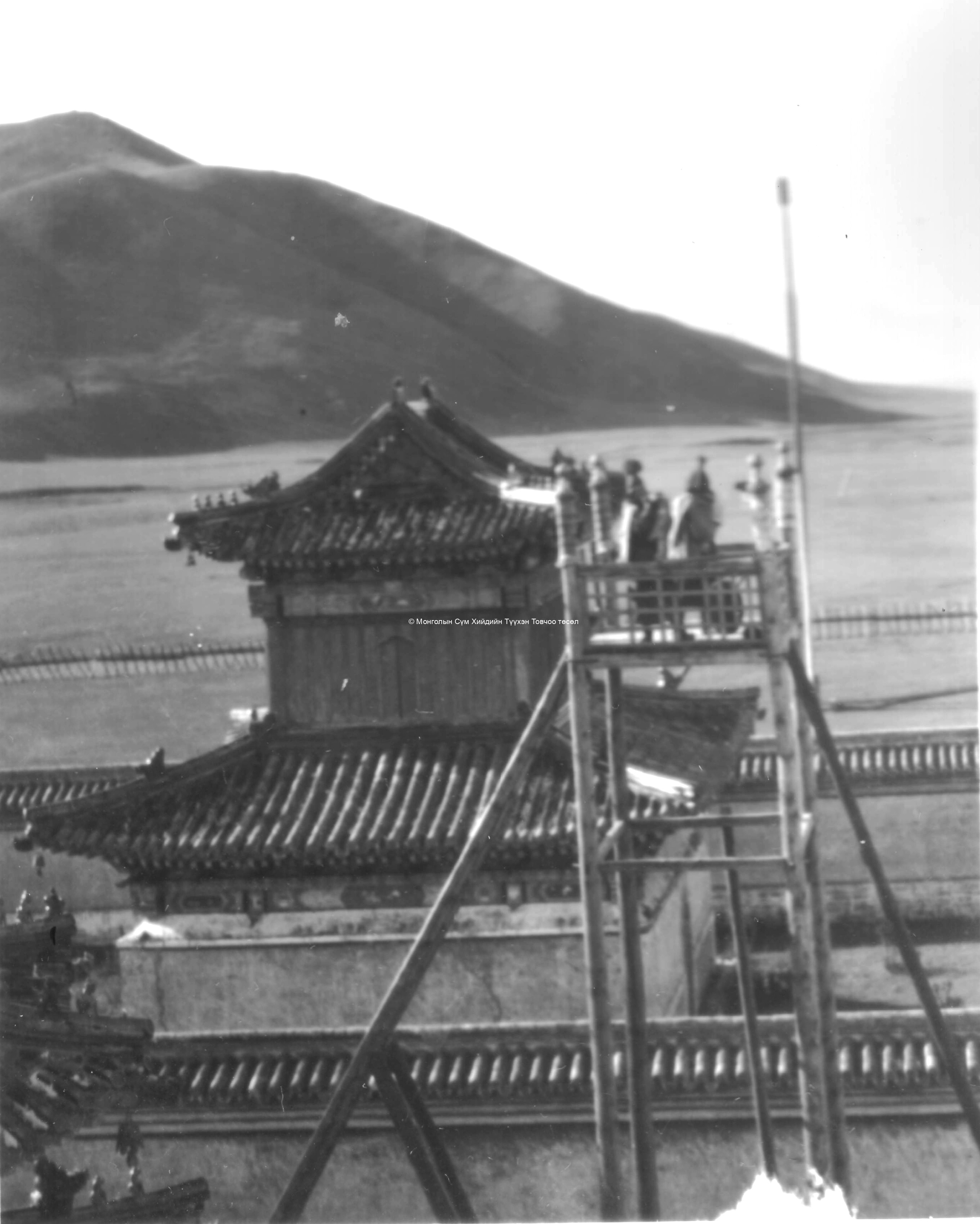 Two monks, wearing shashir ceremonial caps, call monks for a ceremony. Film Archives K-23778
